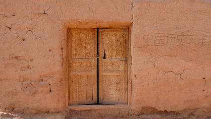 Ancient traditional residential old house wall and wooden door in Tuyoq village valley inTurpan Xinjiang Province China.