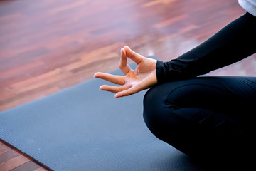 Young sporty woman practicing yoga, doing Padmasana exercise, Lotus pose, with mudra gesture,...