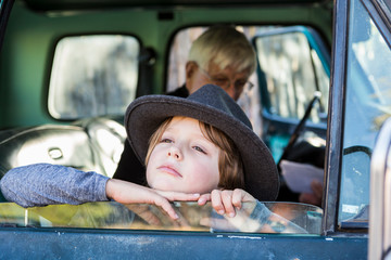 senior grandfather and his 6 year old grandson in vintage pick up truck