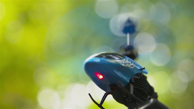 Small toy helicopter in the forest outdoors hovering in the air HD