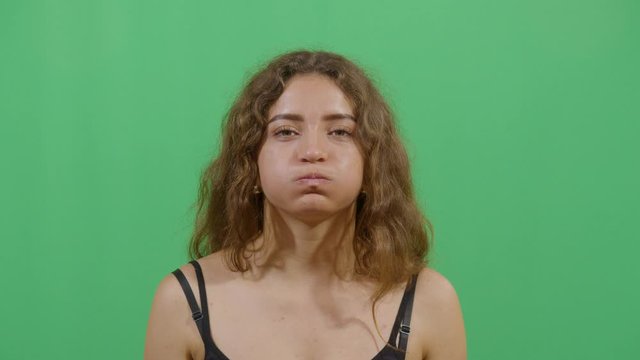 Woman Inflating The Cheeks. Studio Isolated Shot Against Green Screen Background