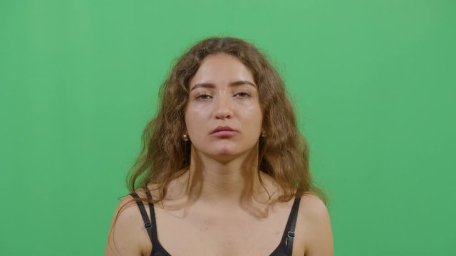 Facial Expression Of A Woman Pouting. Studio Isolated Shot Against Green Screen Background