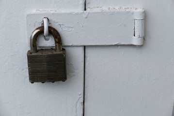 Old lock on a painted  white,metal door