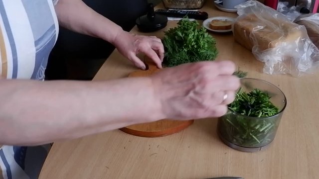 woman cuts dill abd parsley