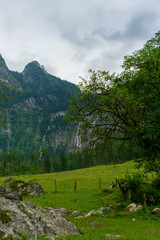 A green mountain meadow with a waterfall in the background - 295574665