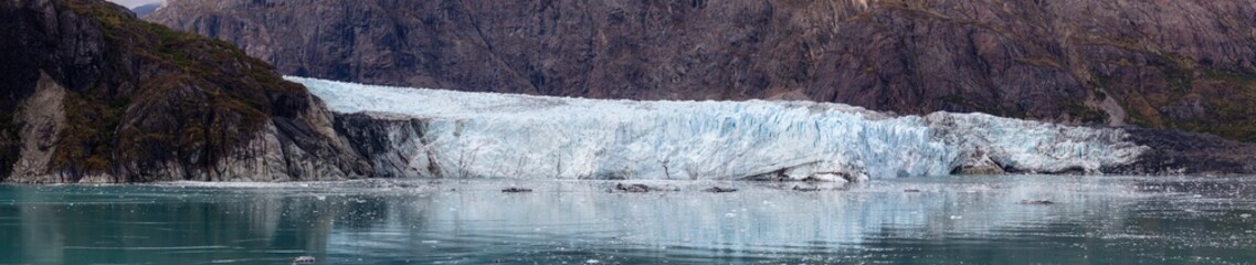 Beautiful Panoramic View of Margerie Glacier in the American Mountain Landscape on the Ocean Coast during a cloudy morning in fall season. Taken in Glacier Bay National Park and Preserve, Alaska, USA.
