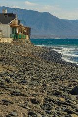A rocky coast on the Canary islands with mountains in the background - 295574881