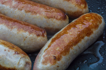 delicious sausage fried in a pan with rapeseed oil - 295574894