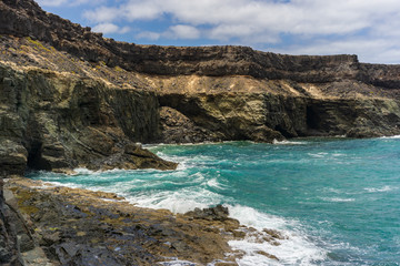Fototapeta na wymiar a rocky coastline with blue water on the canary island fuerteventura
