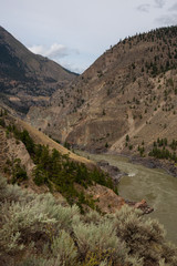Aerial Panoramic View of Fraser River running in the valley surrounded by Canadian Mountain Landscape during summer time. Taken near Lillooet, BC, Canada.