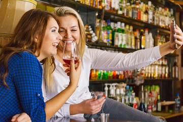Girls in pub club taking self photo with phone