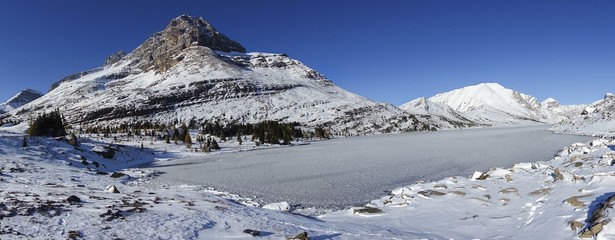 Snowcapped Mountain Peaks and Ice Covered Frozen Ptarmigan Lake Wide Panoramic Landscape on a Sunny Autumn Day in Banff National Park, Alberta Canada