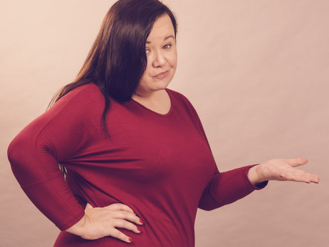 Woman in red pointing with doubt