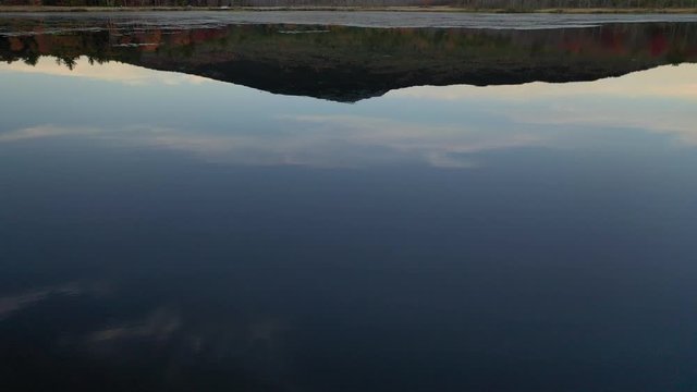 Aerial 4K drone shot of Mount Monadnock over pond with reflection on water surface