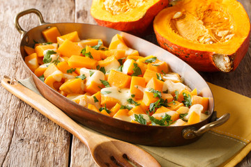 Healthy pumpkin casserole with mozzarella cheese and herbs close-up in a baking dishe. horizontal