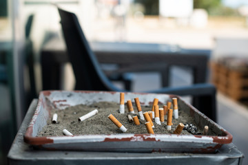 Ashtray with sand and buried cigarettes.