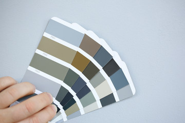 The designer holds pantone fan of color guide in hand. Selection of colors for the color of the walls apartment distribution during promotion concept