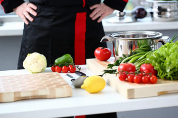 The cook in the kitchen is preparing to prepare a dish of fresh vegetables for a vegan, keeps his...