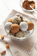 Energy balls with cocoa and nuts in a glass bowl on a white background