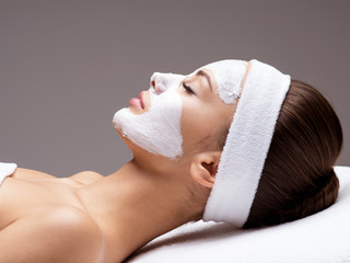 woman relaxing in spa salon with cosmetic mask on face