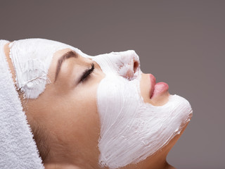 woman relaxing in spa salon with cosmetic mask on face