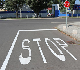 Stop sign and pole in the road crossing