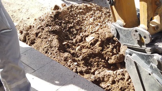 excavator removing asphalt  on a street for reconstruction