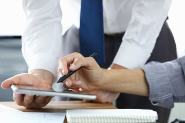 Focus on colleagues hands holding modern tablet and stylos. Businessmen discussion new biz project. Designers creating start-up. Creative work concept. Blurred background