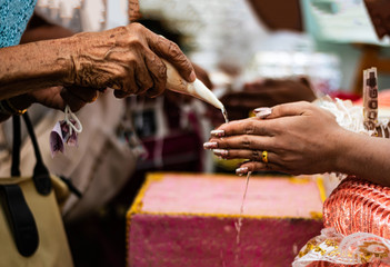 Elderly women pour the conch into their wedding hands. Asian wedding ceremony creating a shared future for men and women. Marriage makes the couple happy. Making life hopeful and peaceful married.