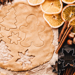 Christmas and New Year celebration traditions. Family home bakery, cooking traditional festive sweets. Gingerbread dough with christmas theme shapes and raw cookies