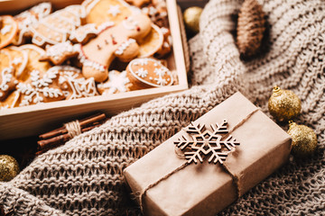 Christmas and New Year traditions concept. Gingerbread cookies, decorations, gift boxes and knitted blanket
