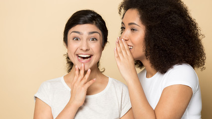 Happy multiethnic millennial girlfriends gossip share secrets