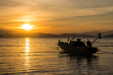 Obraz premium Long tail boat at sunset