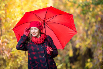 Beautiful woman portrait in autumn garden in bright outfit