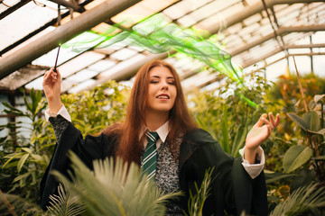 A girl from the school of young wizards with a magic wand in his hand. Green magic. A sorceress...