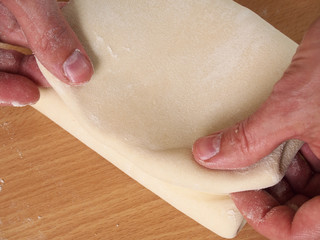 Fold up dough. Fold the lower third of the pastry over the centre third, and the top third of the pastry down over that. Making Puff Pastry Series.