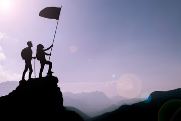 friend holding flag on top mountain. Conception of winner, success and leadership