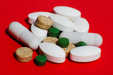 Different pills on a red background