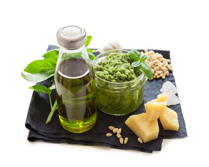 Green italian homemade sauce pesto made of ground basil, garlic, pine seeds, olives and pecorino sardo cheese. View isolated on white background