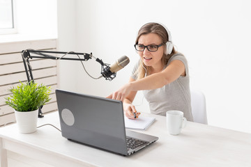 Radio, dj, blogger and people concept - young woman presenter working on the radio studio and...