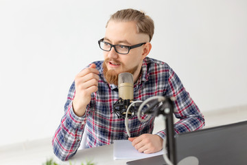 Blogger, streamer and people concept - Close-up of funny young man DJ working on the radio