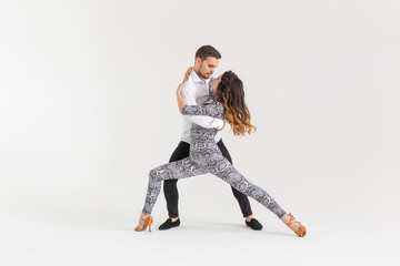 Social dance, bachata, kizomba, zouk, tango concept - Man hugs woman while dancing over white background with copy space