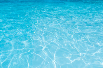 Blue water surface in swimming pool with sun reflection,  Ripple wave in pool for background and...