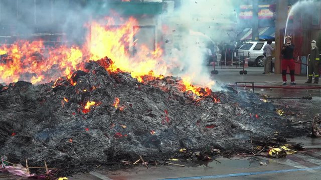 	 Texture of burning joss paper known as ghost money in ceremony faith of Chinese people. Global warming and environmental pollution concept. fire on black background in 4K