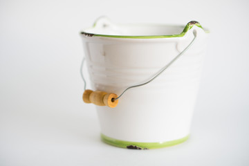 white garden bucket with a green border and a wooden handle on a white fna isolated