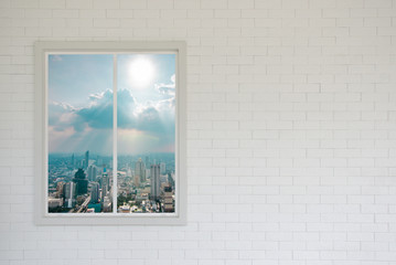 Blank brick wall in white and modern window with skyscraper view and sunlight