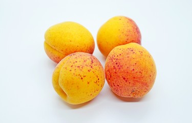 Ripe tasty juicy apricots located on a white background