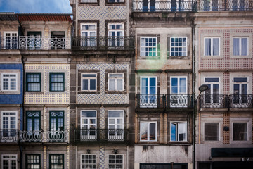 Fototapeta na wymiar Historic old city buildings with portuguese tiles on the facade in Porto. Front view of typical portugal houses with balconies