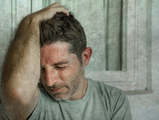 Obraz premium dramatic portrait of sad and depressed 30s or 40s man in pain feeling stressed and broken suffering depression problem and anxiety crisis looking desperate crying lonely