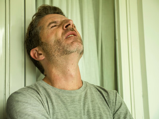 Obraz premium dramatic portrait of sad and depressed 30s or 40s man in pain feeling stressed and broken suffering depression problem and anxiety crisis looking desperate crying lonely